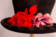 Carica l'immagine nel visualizzatore di Gallery, Cappello artigianale made in Italy in morbido feltro velour di lapin neroguarnito da una coppia di rose rosse di velluto e dall'ala bordata torçon da un prezioso nastro di velluto nero. Top hat tra i più iconici e amati da sempre