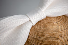 Carica l'immagine nel visualizzatore di Gallery, Spiritoso fiocco in fibra vegetale bianca appoggiato su un sottile cerchietto di raso.