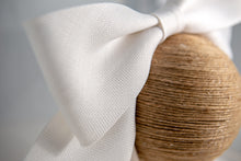 Carica l'immagine nel visualizzatore di Gallery, Spiritoso fiocco in fibra vegetale bianca appoggiato su un sottile cerchietto di raso.