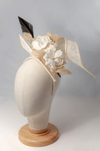 Carica l'immagine nel visualizzatore di Gallery, Toque composta da un ricciolo di sisal che racchiude un tralcio di gardenie in lino da cui spicca una piuma nera. Poggia e scorre su un cerchietto in tinta. Un must della collezione Chapeau Flambe White Bridal.